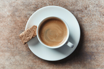 Cup of coffee with cantuccini (Italian biscuit) on rustic stone background. Top view. Copy space.