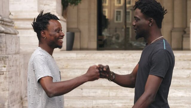 Two black friends, two African American greet each other with their fists