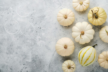 Halloween festive autumn background. Autumn decor from pumpkins, berries, maple leaves and chestnuts on old rustic stone tiles backgrounds. Concept of Thanksgiving day Halloween. Top view copy space