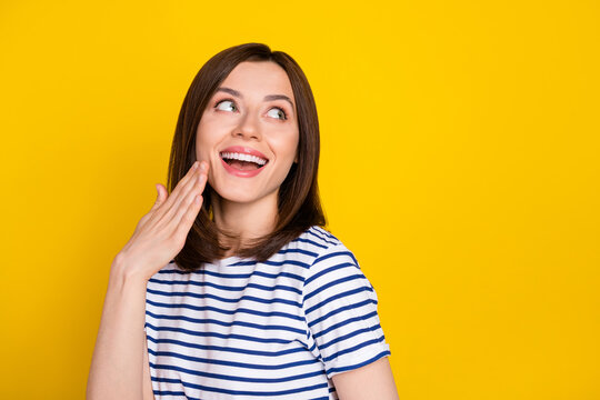 Photo portrait of gorgeous young lady look empty space hand mouth oops dressed trendy striped look isolated on yellow color background