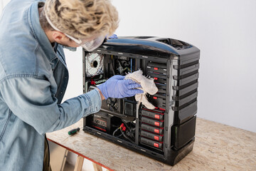Man cleaning pc cabinet with piece of cloth. Unrecognizable person