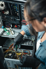 Female computer repair service working on pc cabinet. Close up.
