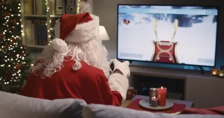 Happy Santa Claus playing video games at home - Powered by Adobe