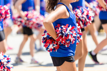 Cheerleader Holding Red, White, and Blue Pom Poms at Fourth of July Parade, American Cheerleader