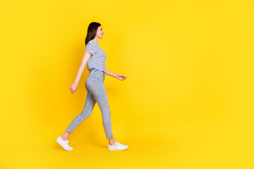 Fototapeta na wymiar Full size profile photo of gorgeous satisfied lady walking toothy smile look empty space isolated on yellow color background