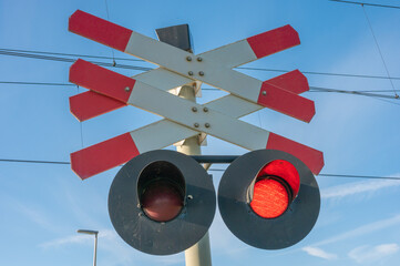 Sign of double railroad crossing with blue sky in the background.