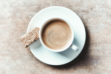 Cup of coffee with cantuccini (Italian biscuit) on rustic stone background. Top view. Copy space.