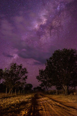 Naklejka na ściany i meble night photo with milky way in the starry purple sky