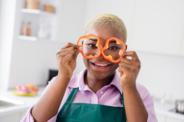 Portrait of funky crazy girl hold two paprika slices watch see glasses kitchen indoors