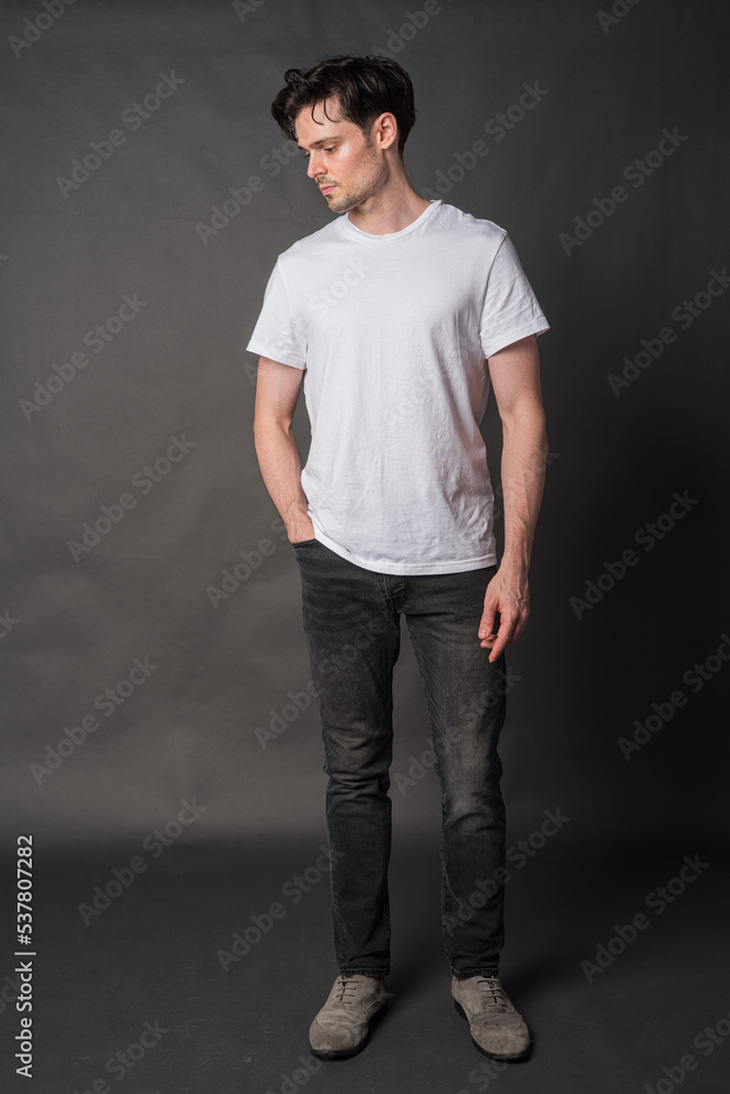 Wall mural Full length studio portrait of handsome man standing against gray background