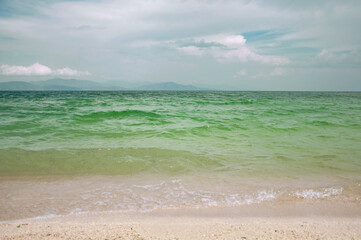 Seascape. Mountain lake shore. A pond with emerald-colored water.