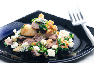 mixture of beef meat, spinach, beans and blue cheese