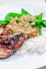 pork steak with onion sauce, green beans and rice