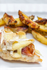 poultry meat grilled with parma ham and brie cheese served with roasted potatoes