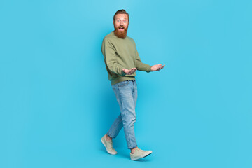 Full size photo of handsome young guy carry hold empty space invisible box walking wear khaki look...