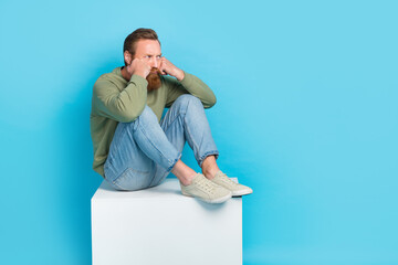 Full size photo of handsome young guy sit offended annoyed depressed white platform wear khaki...