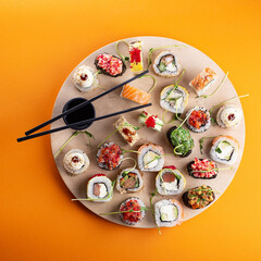 sushi on wooden plate and orange background