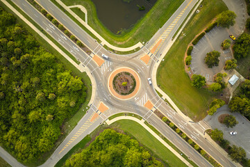Aerial view of road roundabout intersection with moving cars traffic. Rural circular transportation...