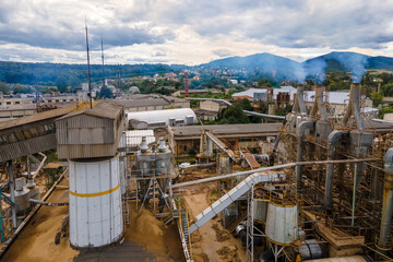 Aerial view of wood processing factory with smoke from production process polluting atmosphere at plant manufacturing yard