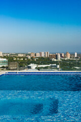 Barranquilla, Atlantico, Colombia. July 30, 2022: Swimming pool from a building and view towards the city with beautiful blue sky.