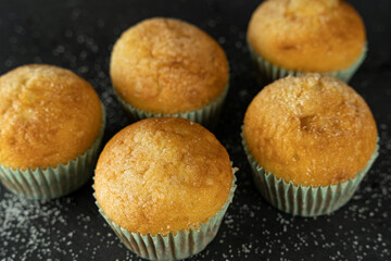 Set of delicious freshly baked cupcakes with sugar on top on a background
