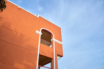 Fragment of red brick resort hotel exterior under blue summer sky