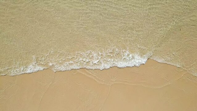 Top view of beautiful tropical beach seamless loop footage. Amazing Sandy coastline with turquiose sea waves. Beautiful Aerial view of white sand beach and blue water.