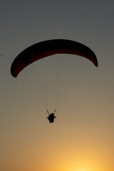 Silhouette paragliding at sunset in Oludeniz.
