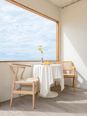 Wooden desk and chair are decorative with flower and tablecloth for relax and working with blue sky