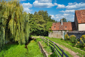 Small river and footpath along the city wall of the medieval town of Moulins-Engilbert, department of Nièvre, Morvan, France
