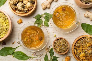 Herbal tea with ingredients on wooden background, top view