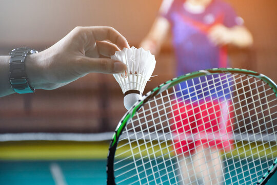 Men single badminton player holds racket and white cream shuttlecock in  front of the net before serving it to another side of the court, soft and  selective focus. Photos | Adobe Stock