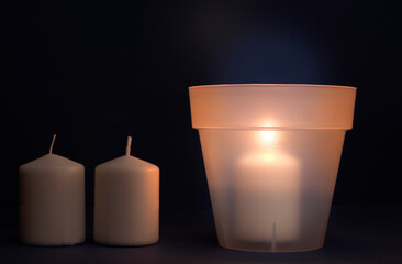 concept energy cuts, DIY lamp, pot and candle indoors, on the desk, dark blue background
