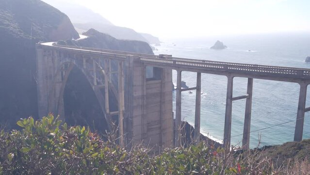 Bixby creek bridge, arch architecture. Pacific coast highway 1 landmark. Historic scenic Cabrillo road. Coastal road trip, journey or travel by ocean. Canyon in foggy weather. California, Big Sur, USA