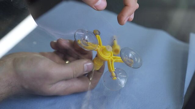 Professional windshield repairman working with hydraulic polymer crack filler. Repair cracks and chips on windshields