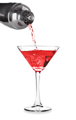 Martini cocktail poured from shaker into glass isolated on white