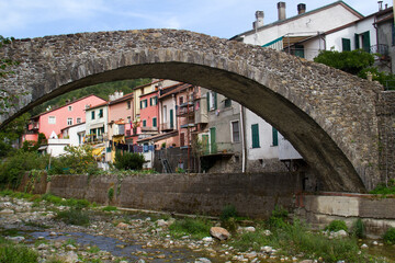 Climate change: arch bridge over an almost dry river in a village