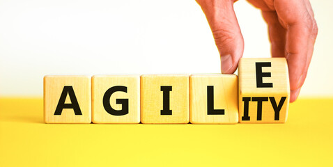 Agile and agility symbol. Concept words Agile and Agility on wooden cubes. Beautiful yellow table...
