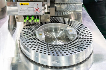 close up medicine green capsule at feeding fork of automatic capsule filling machine during manufacturing process in industrial