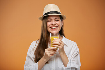 Happy emotional woman with eyes closed holding orange juice drink in glass. Isolated female...
