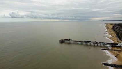 Aerial view of Southwold coastline with views of the pier and waves crashing onto the beach. Southwold Suffolk England. 