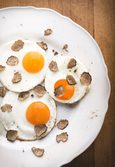 Black truffles and eggs. Gourmet lunch: fried eggs and autumn black truffle, close-up, macro.   Autumn gourmet cuisine of Piedmont, Italy, Spain and France