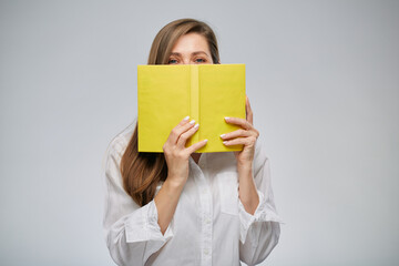 Woman covering her face with yellow book, isolated female portrait.