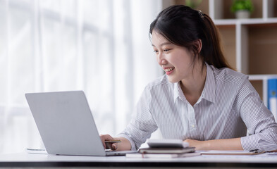 Attractive and charming Young asian woman working on laptop in modern office
