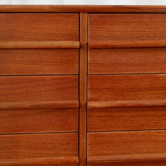 Elegant mid-century modern nine-drawer dresser. Detail view of vintage warm teak furniture.
