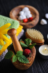 Fresh herbs in wooden mortar and bath bombs