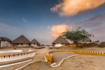 KUTCH, GUJARAT, INDIA: traditional mud huts with thatched roof and painted decoration, called Bhunga - obrazy, fototapety, plakaty