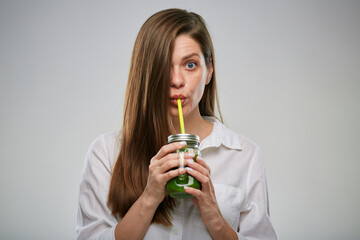 Smiling woman drinking green juice from smoothie jar. Isolated female advertising portrait.