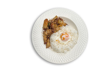 Stir-fried crispy pork belly with chili and salt served with plain rice topped with soft-boiled egg on a white plate