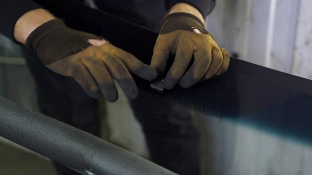 A man pastes a car interior mirror mount
